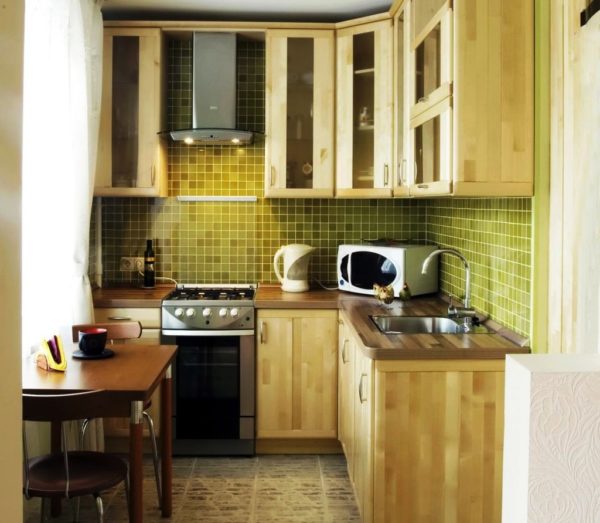 Деревянная мебель в сочетании с оливковым цветом дополнит интерьер маленькой кухни