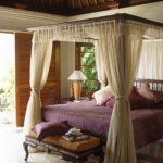 кровать в тропической спальне украшают балдахины